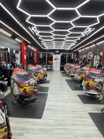 Inside DF Flow: two rows of barber chairs in red and black under hexagon LED ceiling lights